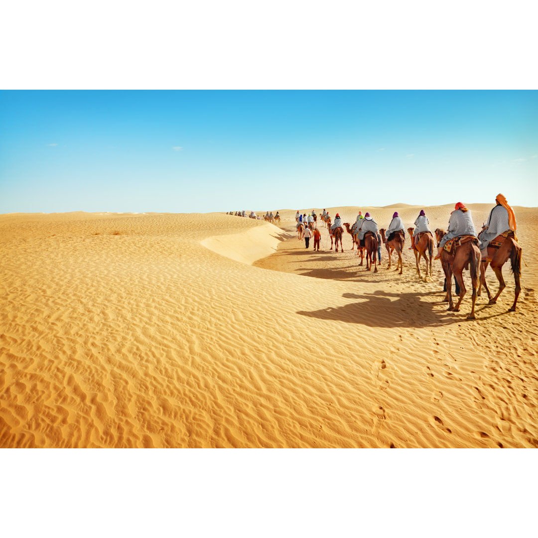 People On Camels Traveling Across The Sahara Desert