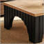 Table basse rustique carrée avec plateau épais et base arquée, alliant style campagnard moderne et durabilité