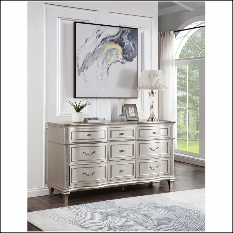 La commode à 9 tiroirs en chêne argenté Katerina avec plateau à bijoux amovible, allie élégance et amplement de rangement pour les chambres à coucher modernes.
