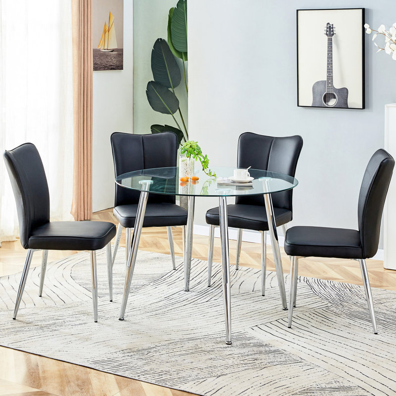 Table en verre transparent avec quatre pieds en métal argenté et 4 chaises rembourrées en PU noir à dossier vertical concis de 38,6 po