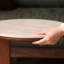 Table basse en chêne massif avec finition noyer, base sculpturale incurvée et plateau en pierre frittée blanche, table de salon moderne