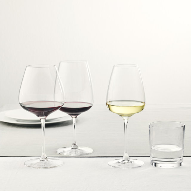 Three wine glasses and one water glass on a table.