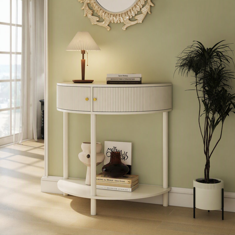 Cette console demi-lune conserve sa silhouette classique en demi-lune, désormais sublimée par des façades de tiroirs ornées d'un motif ondulé en 3D, réalisé artisanalement. La texture semi-circulaire ondulée apporte profondeur et raffinement tactile.