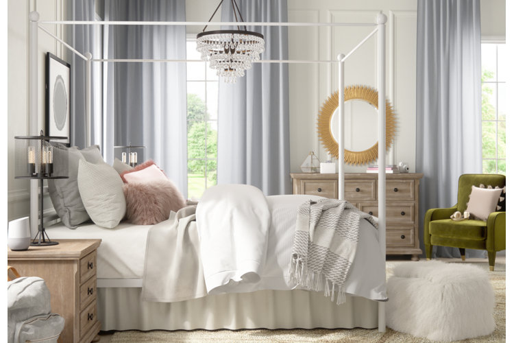 Neutral glam bedroom with white bedding, white walls, gray-blue curtains, and soft pink accents.