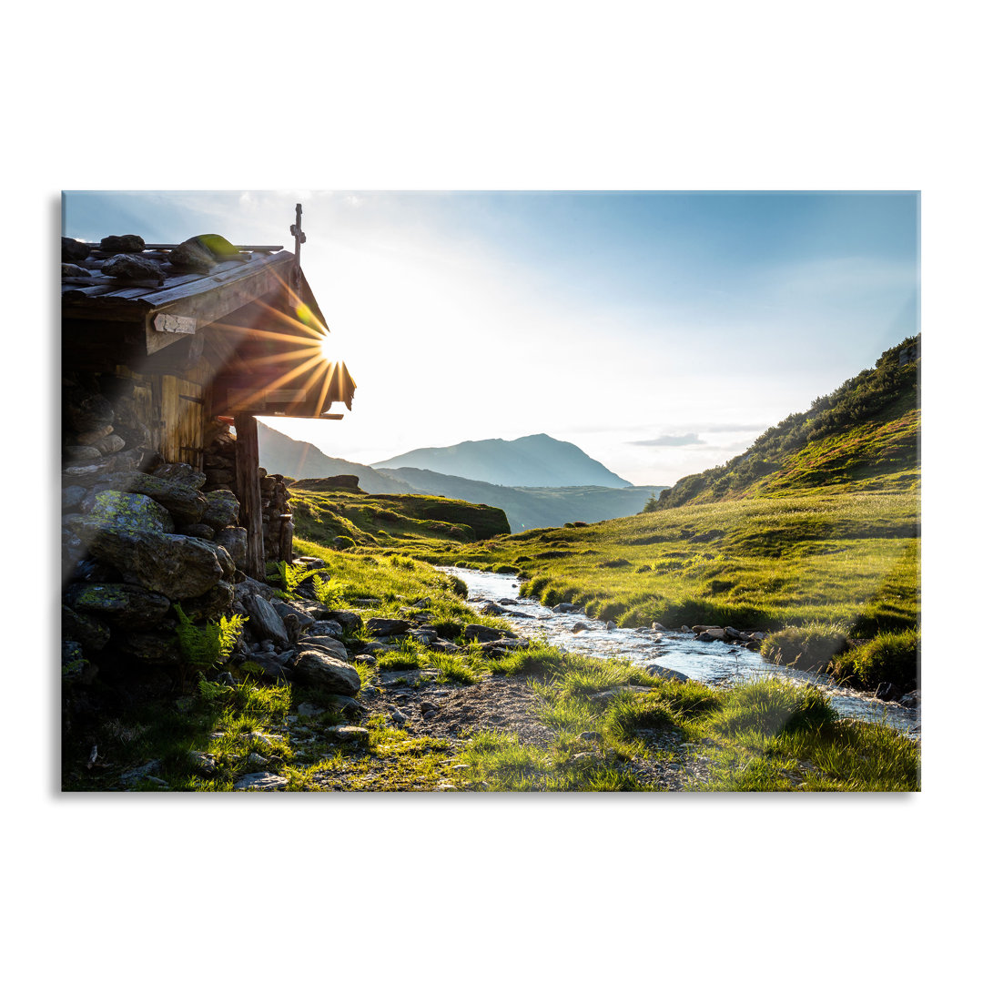 Leinwandbild Almhütte am Bach bei Sonnenuntergang