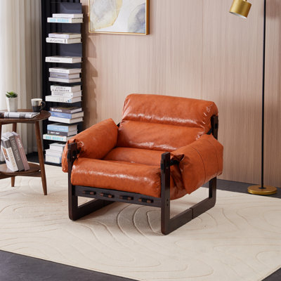 Fauteuil en cuir avec pieds en bois robustes et coussin moelleux