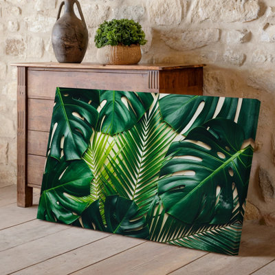 Toile d'un motif tropical vibrant avec un tableau de feuilles d'art luxuriant vert, y compris de grandes feuilles de monstera et de palmiers, ajoutant une toile