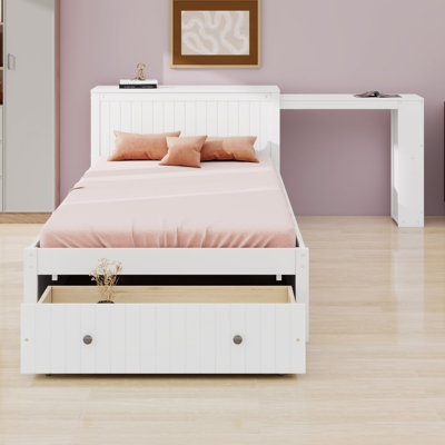 Lit plateforme avec bureau et rangements combinant espace de travail, étagères et tiroirs au pied du lit pour des chambres bien organisées