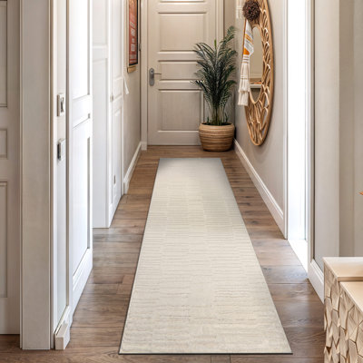 Tapis d'intérieur à poils longs et doux, tissé à la machine, blanc perle, à texture horizontale et à chevrons.