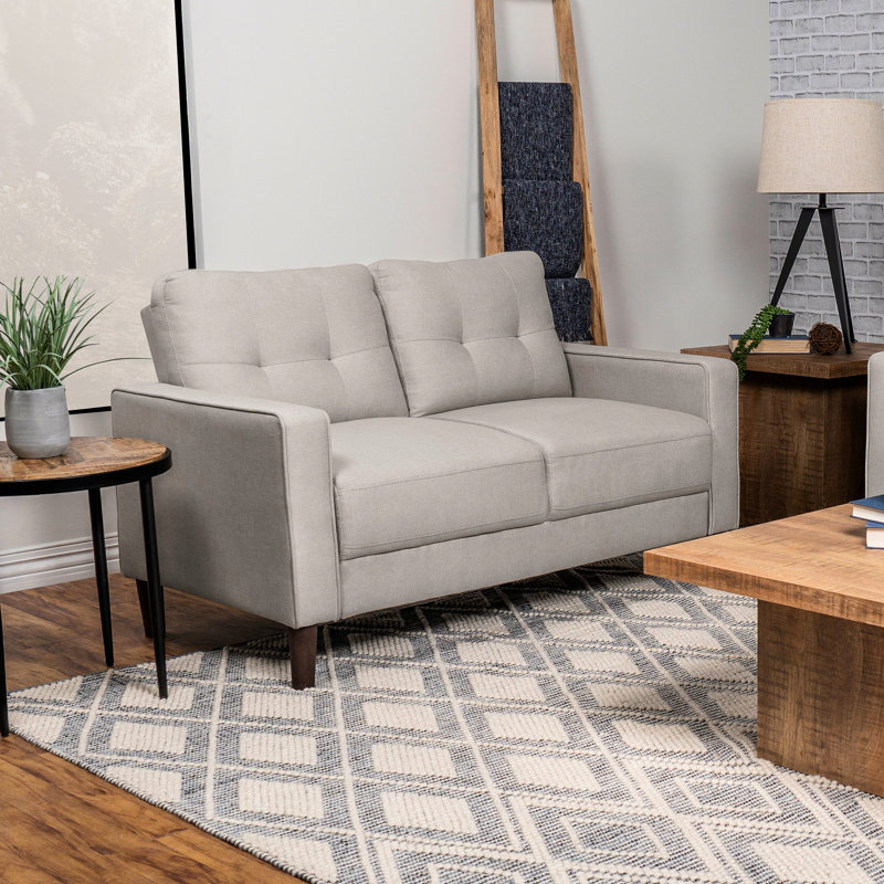 Petit beige tapissier avec détails auto-tissés, dossier quadrillé et accoudoirs, pour les espaces de vie principaux