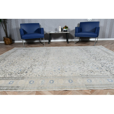 Élégant tapis turc rétro avec des tons neutres et des motifs floraux parfaits pour rehausser le décor de votre salon