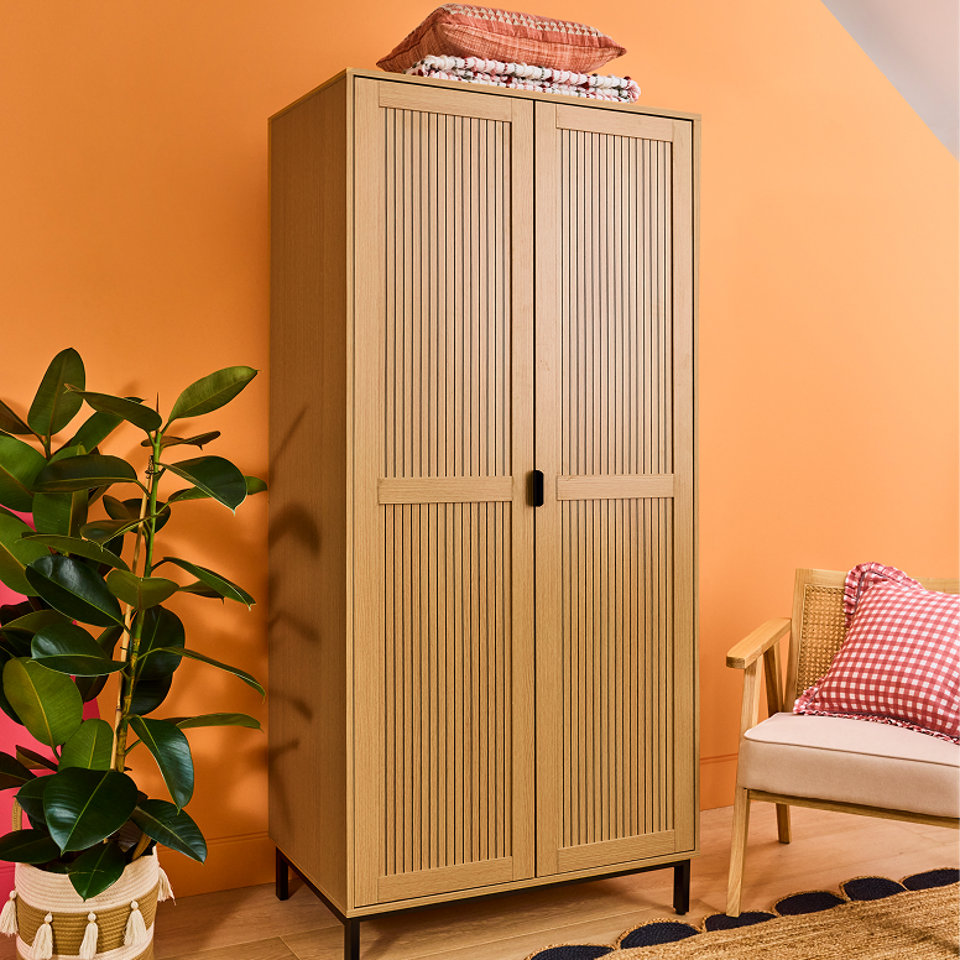 A tall brown wooden wardrobe with two doors.