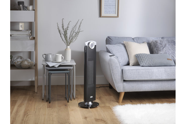 living room with a standing tower fan to keep house cool in the summer with a gray sofa, grey and beige throw pillows, a white shag area rug, gray tables and a light book bookshelf
