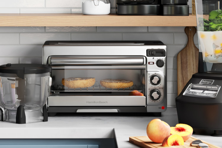 stainless steel toaster oven filled with two bagel halves in a modern kitchen