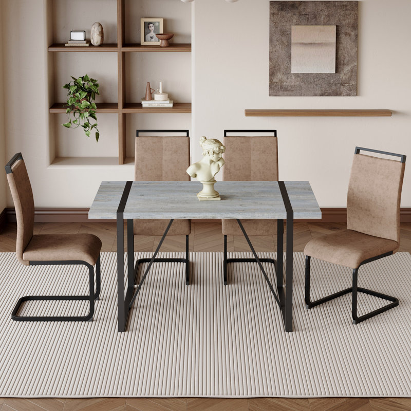 Ensemble de table et de chaises. Table de salle à manger moderne en bois aggloméré texturé en marbre gris minimaliste avec structure en métal et 4 chaises en tissu brun avec pieds noirs arqués.