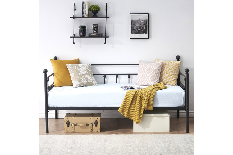 The Korecky black metal daybed with a yellow throw blanket.