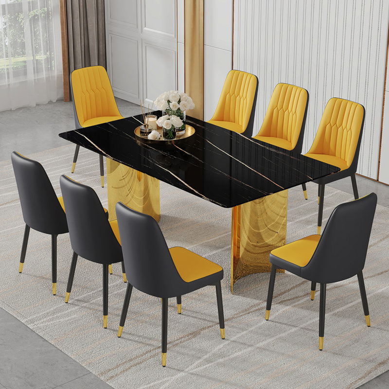 Ensemble de table et de chaises. La table a un plateau en verre avec des autocollants en imitation marbre et des pieds dorés en acier inoxydable. Assorti avec 8 chaises de salle à manger en polyuréthane épissé orange et gris foncé.