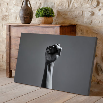 Canvas A Close Up Of A Raised Human Fist Symbolizing Strength Wall Art And Defiance Set Against A Smooth Neutral Gray Background That Canvas Wall Art