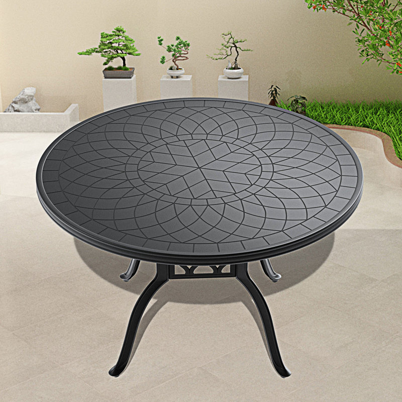 Table de salle à manger en fonte d'aluminium avec texture sculptée sur le plateau de table