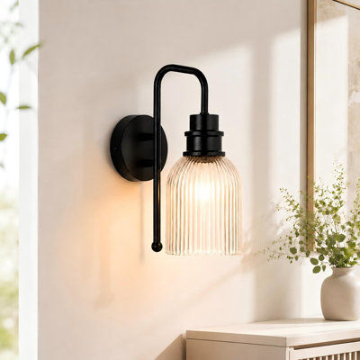 Black wall sconce with Vertical Ribbed Clear Glass shade