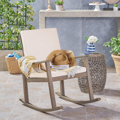 Chaise berçante d'extérieur en bois d'acacia avec coussins et dossier croisé Arend Coastal