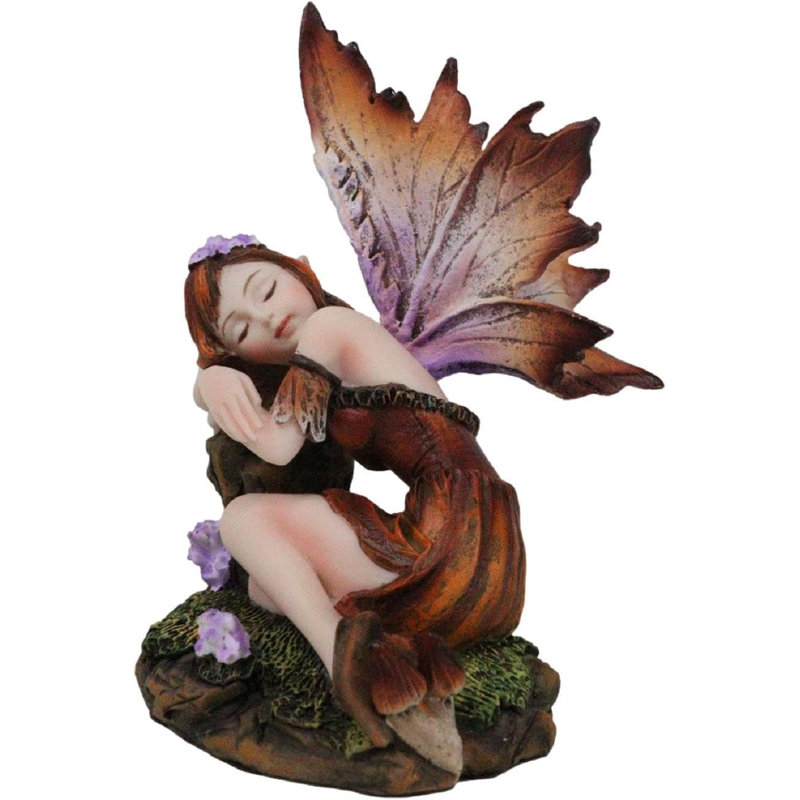 Figurine de fée citrouille endormie dans un jardin enchanté