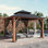 Pavillon de jardin à toit rigide 12 pi x 12 pi Hamilton avec lumières solaires auto-alimentées, moustiquaire et crochet pour auvent