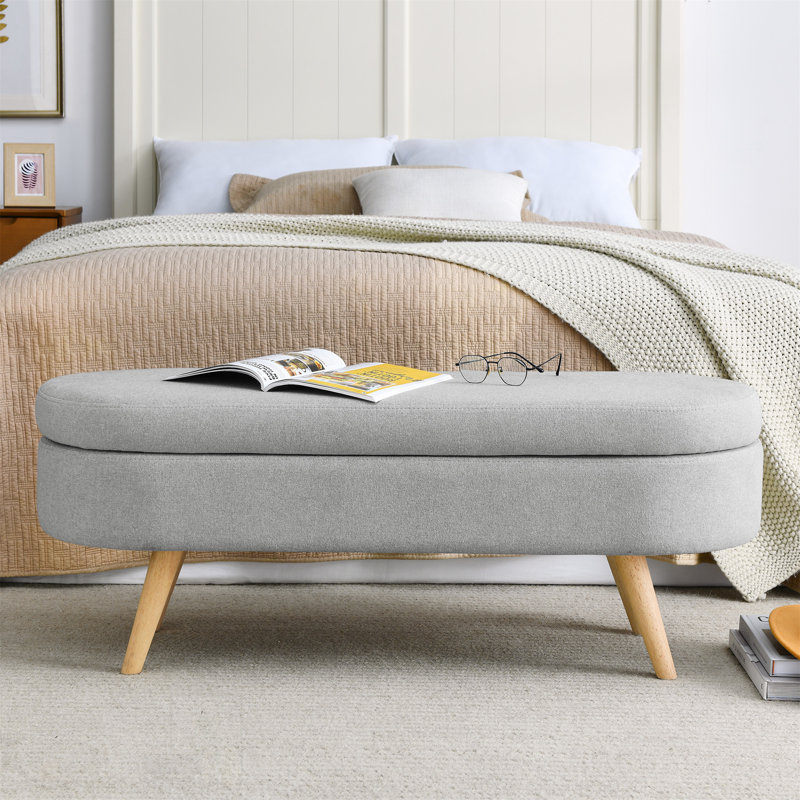 Élégant banc de rangement ovale avec pieds en bois d'hévéa pour sièges supplémentaires et tissu de rangement caché., Gris