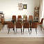 Ensemble de table et chaises de salle à manger moderne et minimaliste avec des pieds en métal en forme de X, une traverse en bois aggloméré et des chaises confortables en techno-tissu.-723711081