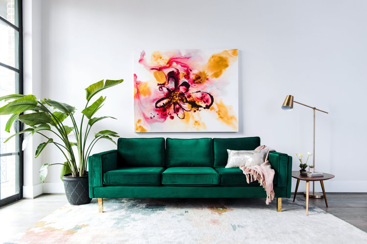 oversized plant next to green sofa
