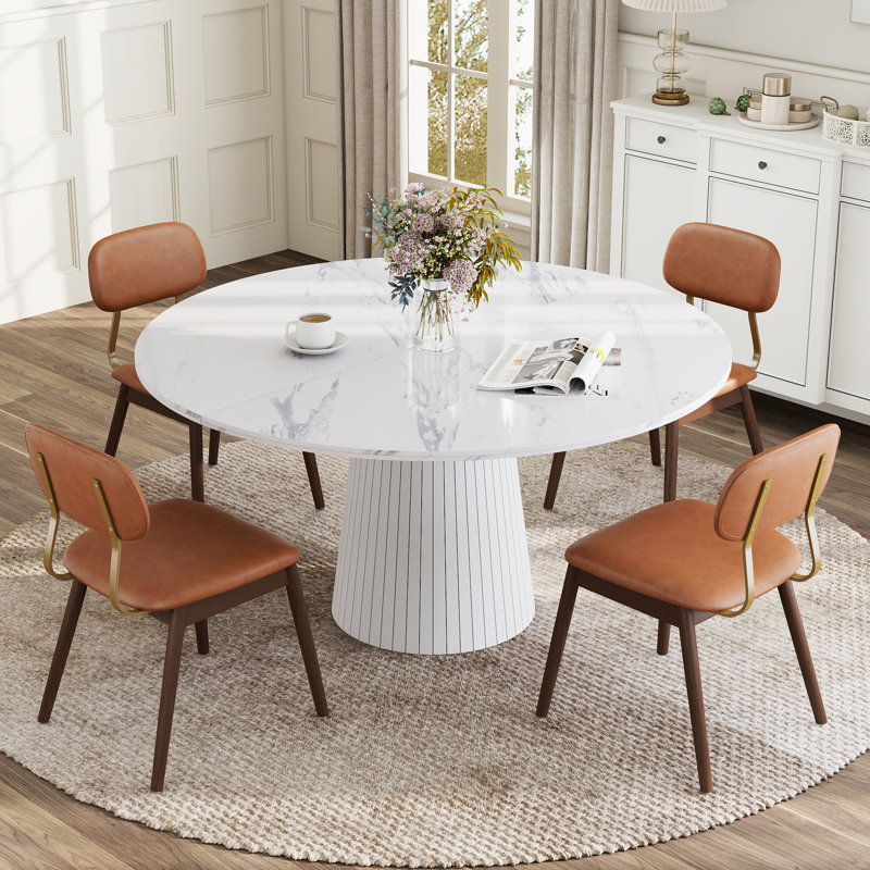 Ensemble de table et chaises de salle à manger rondes modernes de 119 cm (47 po) pour 4 à 6 personnes, avec pied central et chaises rembourrées.