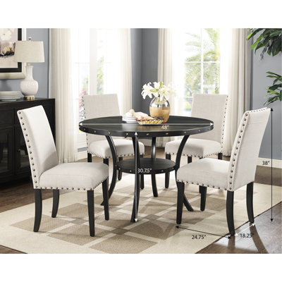 Salle à manger en bois. 5 avec table ronde et 4 chaises. Possède un plateau en bois au fini grain de café et une structure en métal. Les chaises sont ornées de têtes de clou en tissu brun clair, en lin et en coton - 5 pièces. Haricot