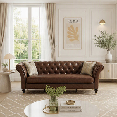 Luxueux canapé Chesterfield en cuir cognac avec capitonnage profond, accoudoirs roulés et pieds en bois rétro pour une décoration intérieure élégante