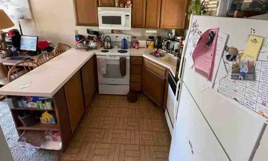 A kitchen with linoleum floors and a peninsula.