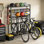Range-vélo noir autoportant et rangement pour le garage, capacité de 4 vélos avec panier et crochets en filet, patins réglables pour la cour et le garage