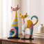 Ensemble de 2 objets décoratifs en résine représentant un chat abstrait jaune