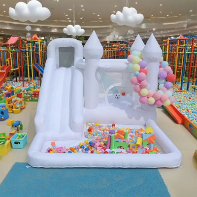 Château gonflable blanc. Équipé d'une glissade, d'une piscine à balles et d'un souffleur, convient aux fêtes d'anniversaire des enfants, à l'Halloween, aux cadeaux de Noël et aux jeux en plein air