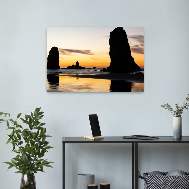 Silhouettes Of Rock Formations At Sunset At Cannon Beach Oregon USA by Dan Merkel - Wrapped Canvas Print
