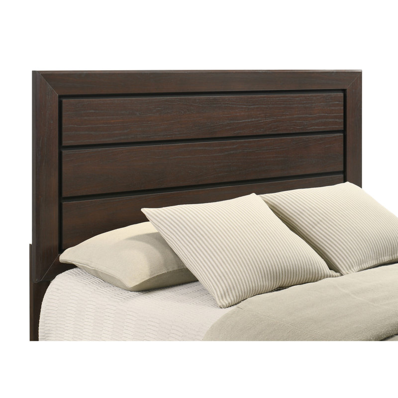 Chambre à coucher avec 5 grands lits foncés avec grain de bois naturel et commode encadrée en chêne