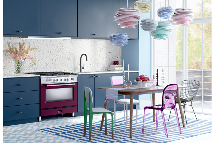 Color drenched kitchen with blue cabinets, terrazzo backsplash, and colorful lighting and seating accents