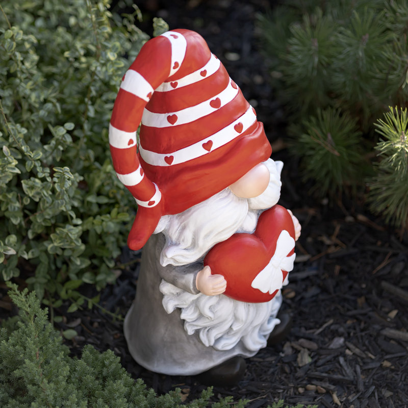 Gnome de jardin en magnésium tenant un cœur avec un nœud et un chapeau rayé rouge "The Valentinos"