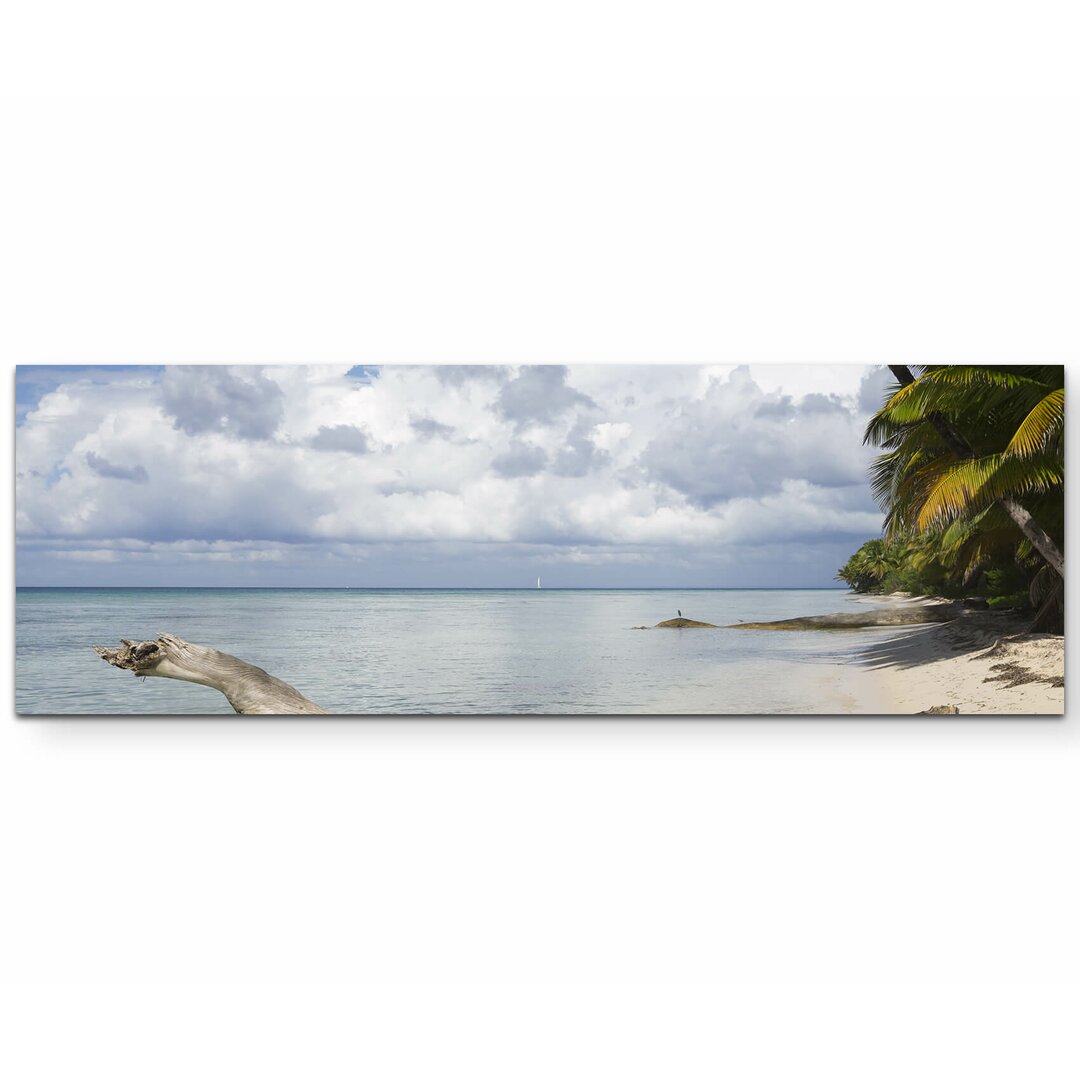 Leinwandbild Am Strand einer tropischen Insel mit blauem Himmel