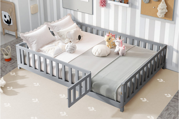 gray montessori floor bed with slatted guardrails in toddler bedroom