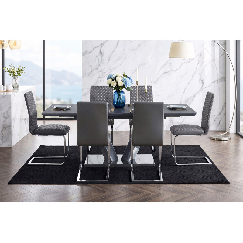 Table de salle à manger moderne et luxueuse à finition frittée avec plateau en forme de V et piédestal en chrome