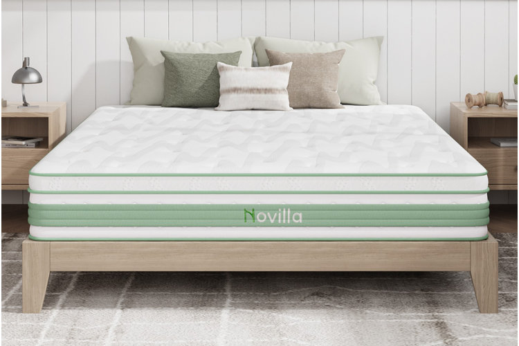 light wood bed frame with white and green mattress and neutral pillows