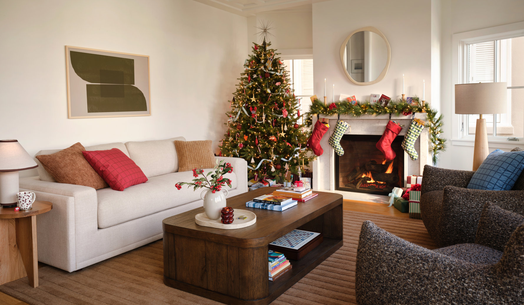 Cozy living room decorated for Christmas with a lit tree, fireplace, stockings, and warm neutral furniture.