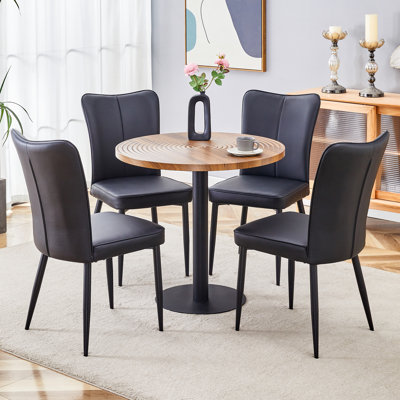 de salle à manger ronde en grain de bois foncé de 4 pouces avec texture de moulage par aspiration, jumelée à 4 chaises en polyuréthane noir avec dossier à rayures verticales et pieds en métal noir