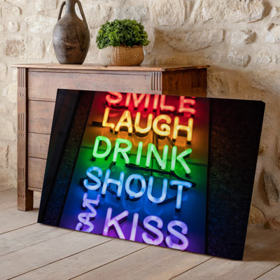 Canvas A Vibrant Neon Sign Featuring The Words SMILE LAUGH TALK Wall Art DRINK SHOUT EAT And KISS Arranged Vertically Against A Canvas Wall Art