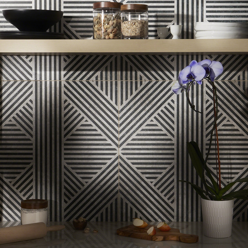 Black and white geometric porcelain wall tile installed as a kitchen backsplash behind a wooden shelf and countertop.