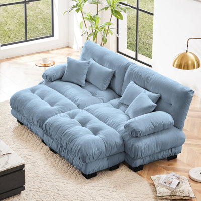 Canapé 2 places en chenille bleue pour salon, coussins d'assise effet nuage, coussins lombaires et décoratifs, poufs assortis, traversin rond au design raffiné